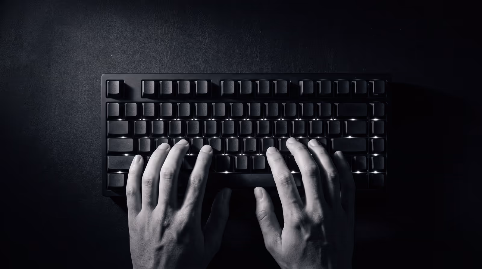 Hands resting on a mechanical keyboard under hard light