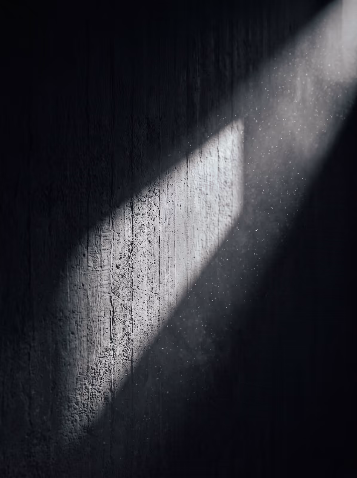 A blade of hard light falling across a studio wall